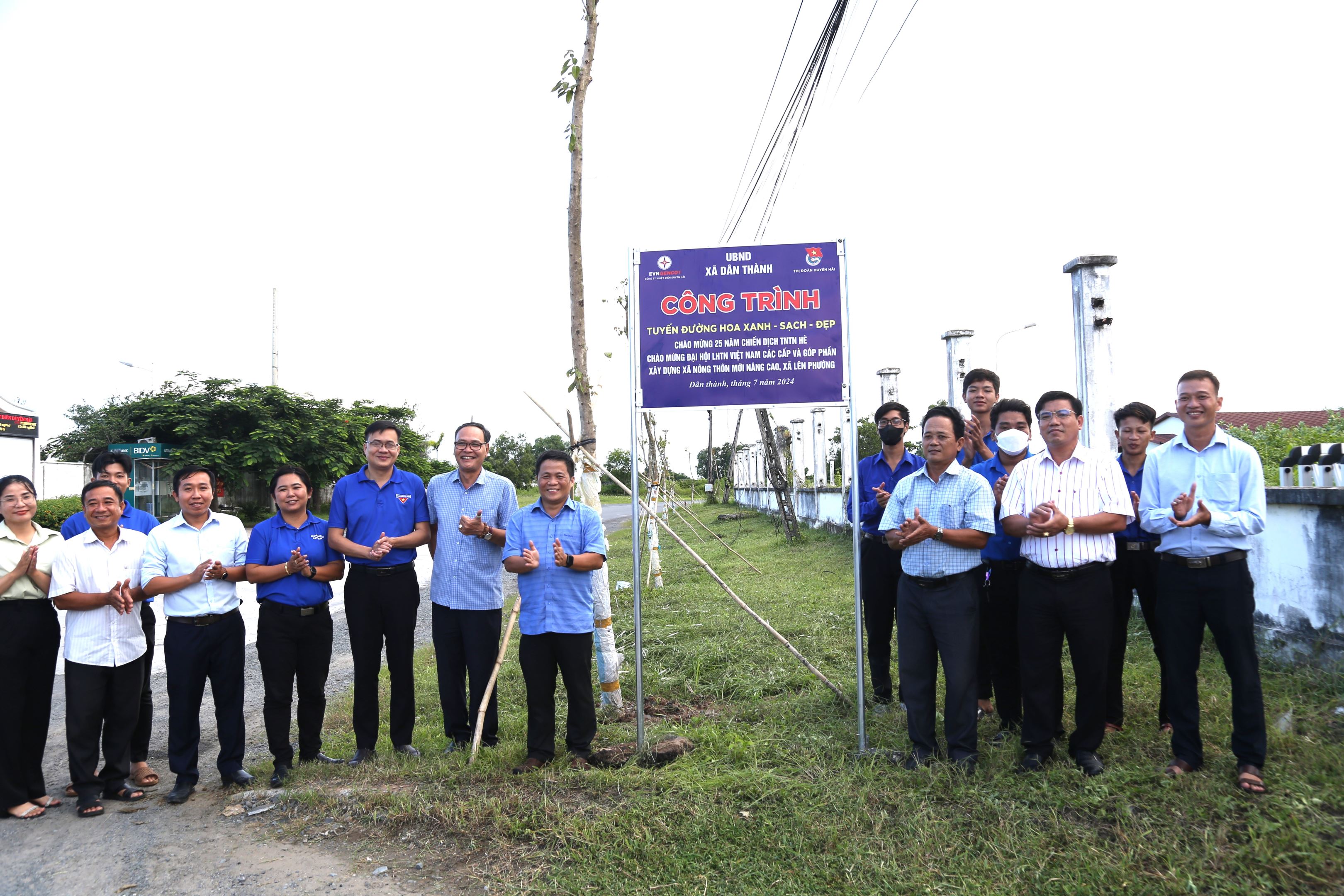 A group of people standing in front of a signDescription automatically generated