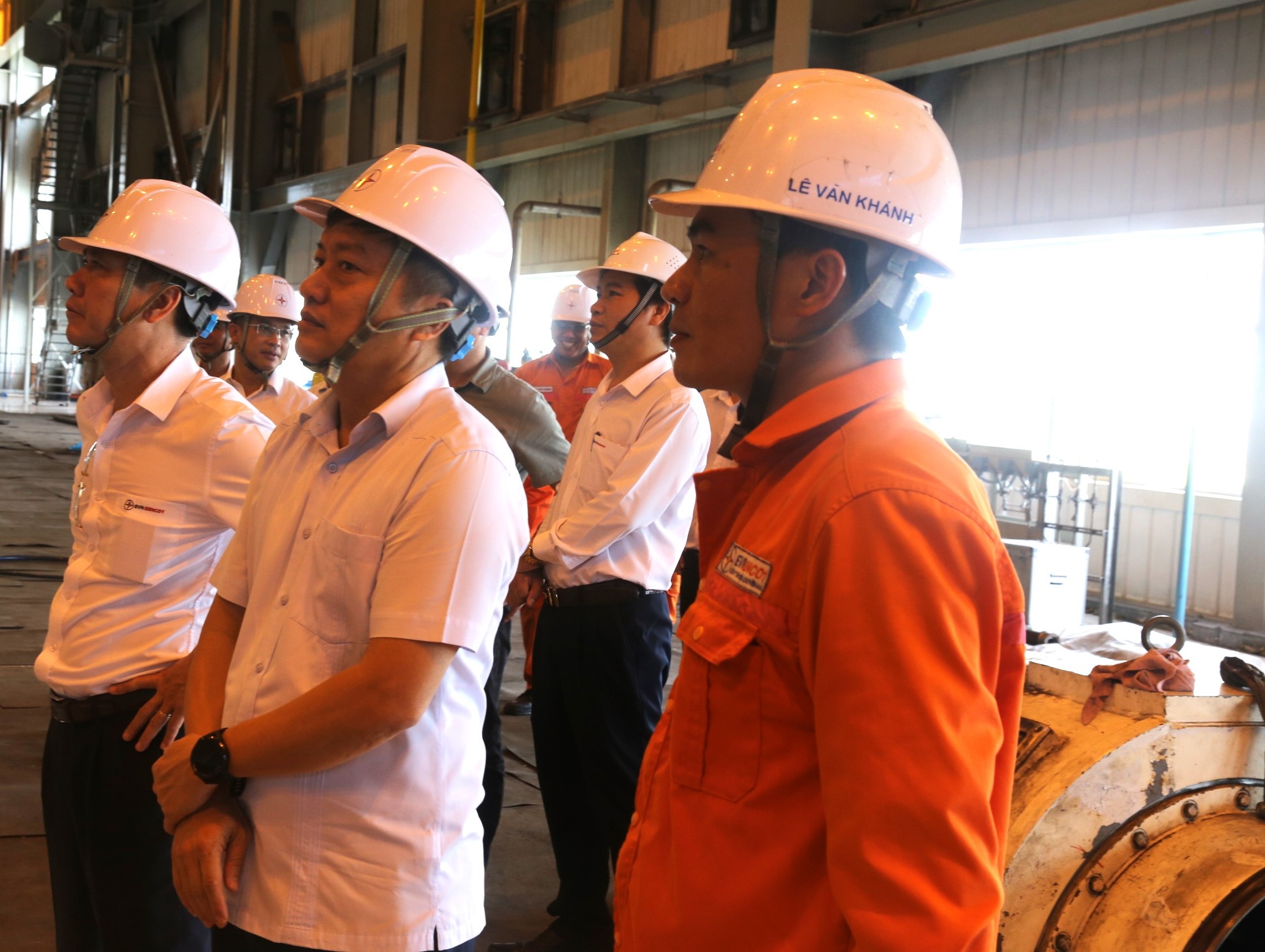 A group of men wearing hard hatsDescription automatically generated