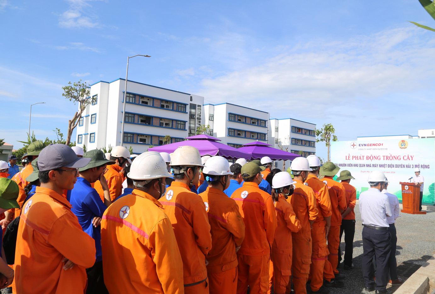 A group of people in orange jumpsuits and helmetsDescription automatically generated